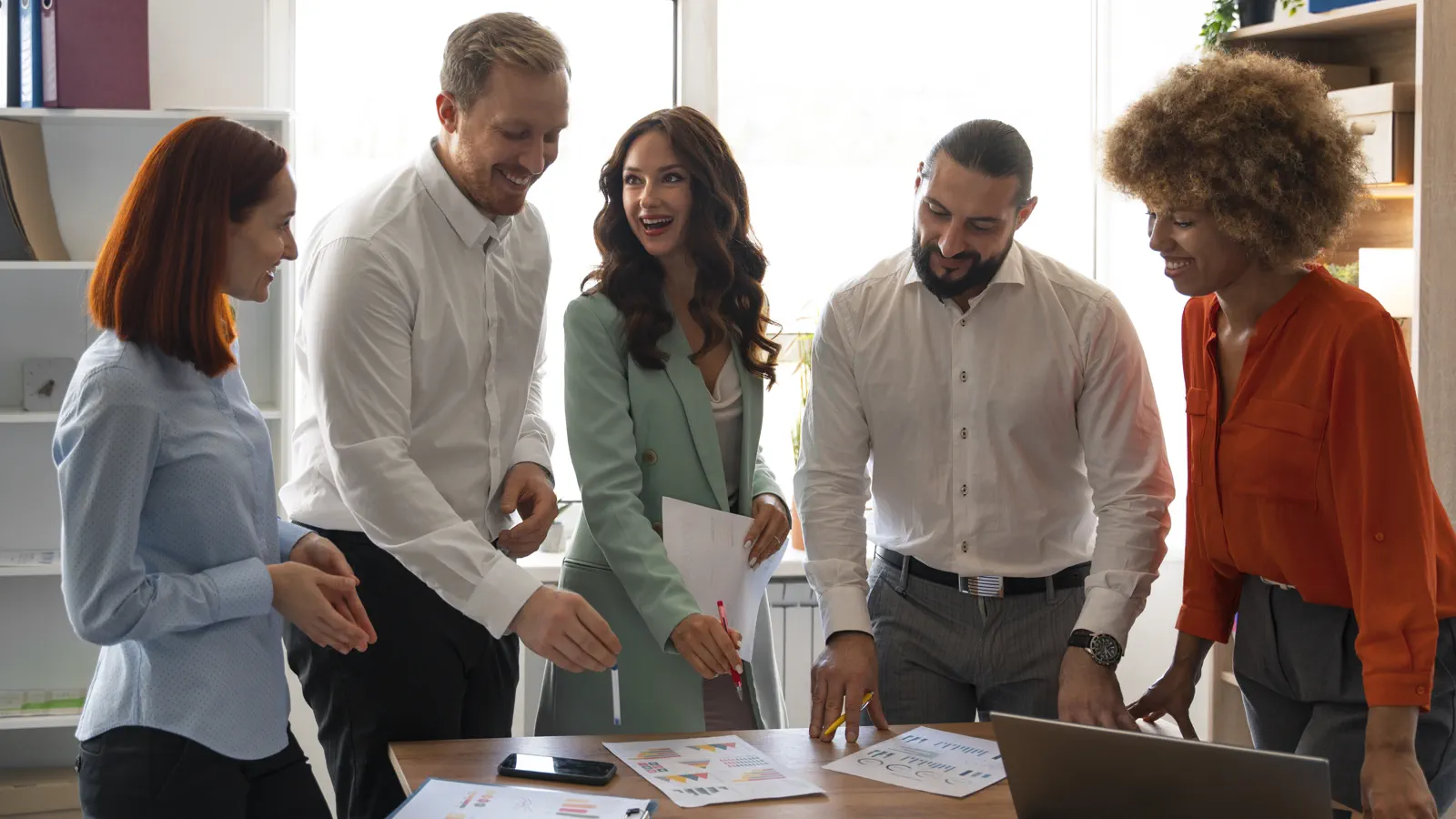 Equipo profesional colaborando alrededor de una mesa de trabajo